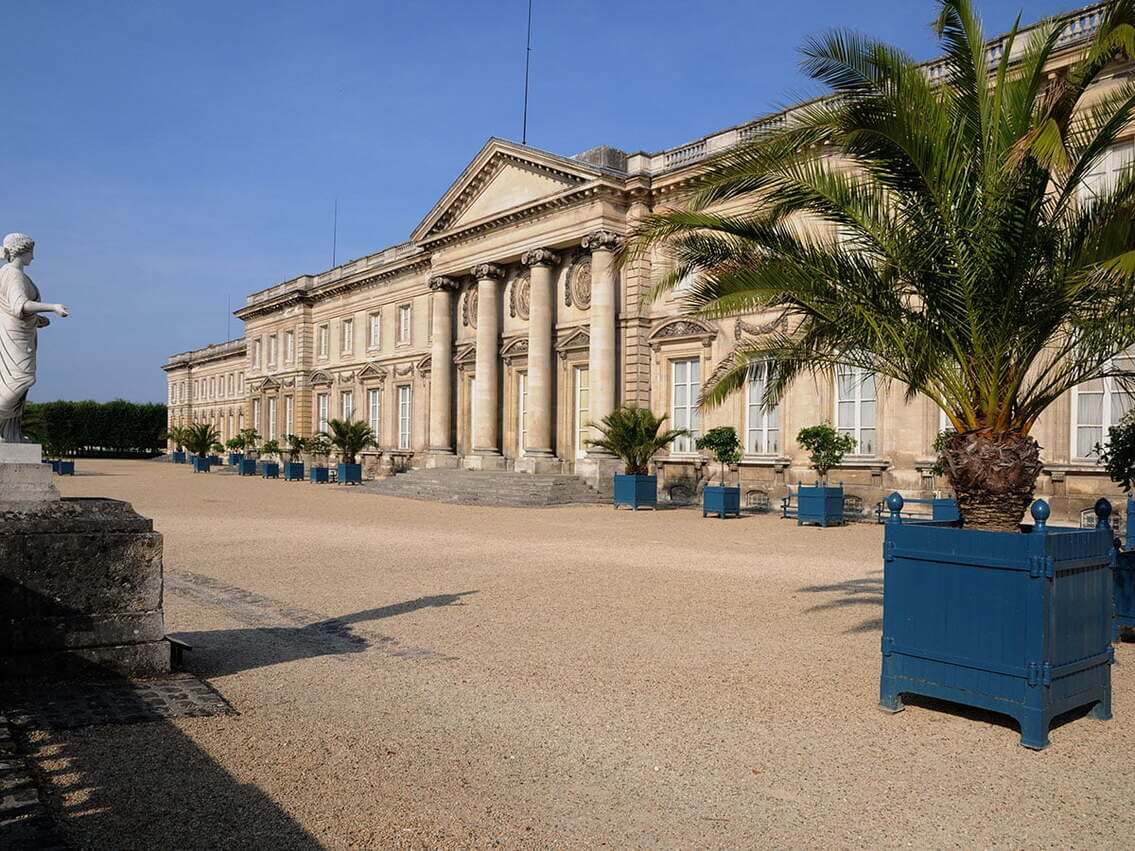 Château de Compiègne vu de trois-quart avec un palmier devant